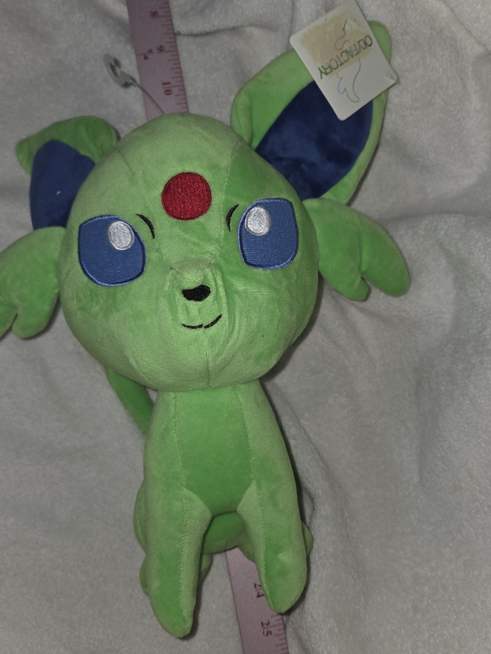 Green Plush Pokemon with Blue Eyes and Red Forehead Accent
